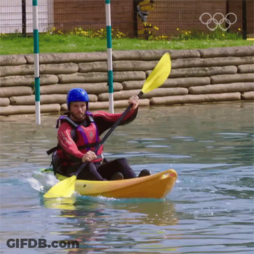 A Man In A Helmet Is Paddling A Yellow Kayak GIF