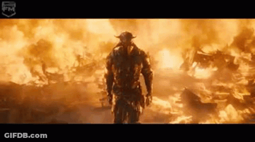Man In Helmet Standing In Front Of Fire GIF