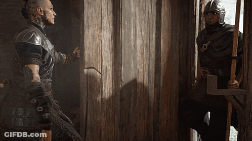 Man In Helmet Standing Next To Man In Black GIF