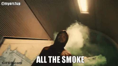 A Man In A Hood Is Holding A Green Smoke Bomb And Says All The Smoke . GIF