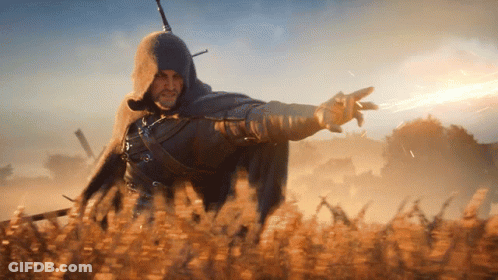 A Man In A Hooded Cape Is Standing In A Field Pointing GIF