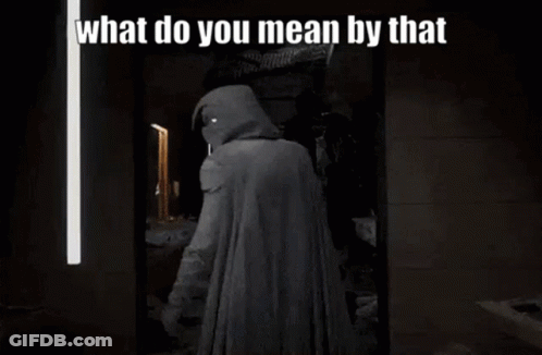 A Man In A Hooded Cape Is Standing In Front Of A Mirror With The Words `` What Do You Mean By That '' . GIF