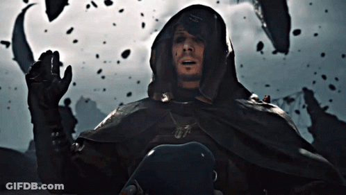 A Man In A Hooded Cape With A Necklace That Says ' A.m. ' On It GIF