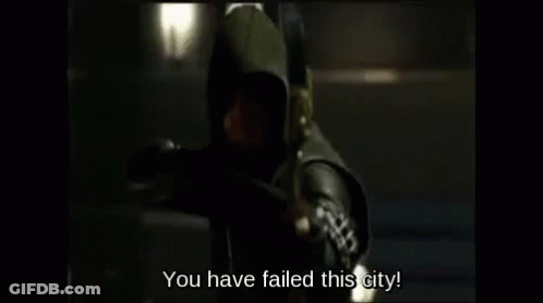 A Man In A Hooded Costume Is Holding A Bow And Arrow And Says `` You Have Failed This City '' . GIF