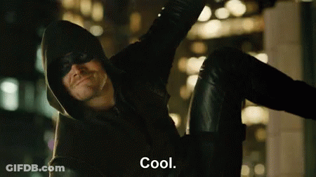 A Man In A Hooded Jacket And Mask Is Sitting On A Wall And Says Cool . GIF
