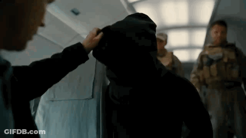 A Man In A Hooded Jacket Is Being Touched By Another Man GIF