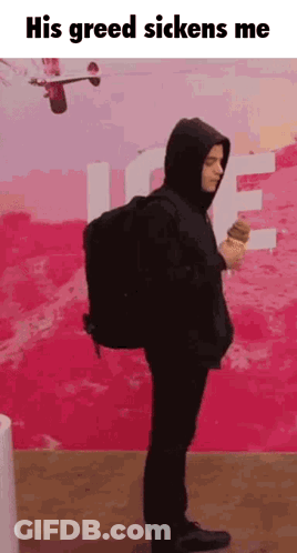 A Man In A Hooded Jacket Is Holding An Ice Cream Cone . GIF