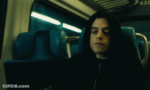 A Man In A Hooded Jacket Is Sitting In A Blue Seat With The Number 43 On The Back GIF