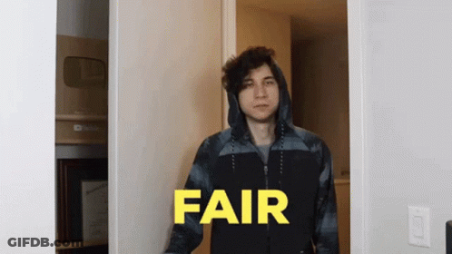 A Man In A Hooded Jacket Is Standing In A Doorway With The Word Fair In Yellow Letters GIF