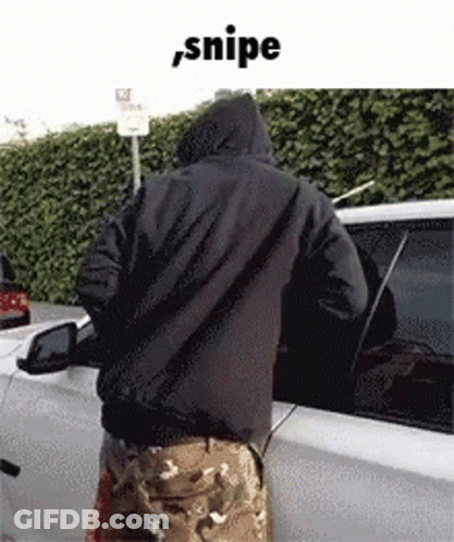 A Man In A Hooded Jacket Is Standing Next To A White Car . GIF