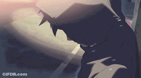 A Man In A Hooded Jacket Is Standing On A Sidewalk GIF