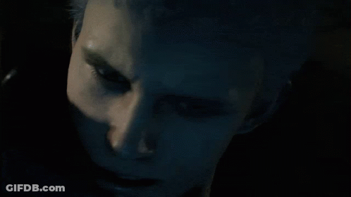 A Man In A Hooded Jacket Looks Down At Something GIF