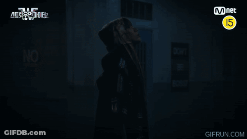 A Man In A Hooded Jacket Stands In Front Of A Sign That Says Do Not Enter GIF