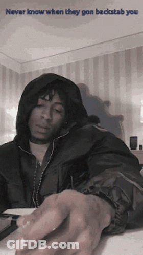 A Man In A Hooded Jacket With The Words Never Know When They Gon Backstab You On The Bottom GIF