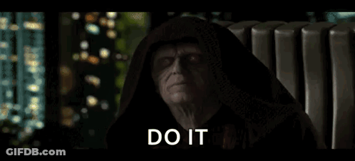 A Man In A Hooded Robe Is Sitting In A Chair With The Words `` Do It '' Written On The Screen . GIF