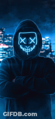 A Man In A Hooded Sweatshirt Is Holding A Purple Light In His Hands GIF
