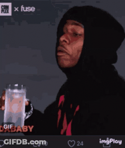 A Man In A Hoodie Holds A Glass Of Water GIF