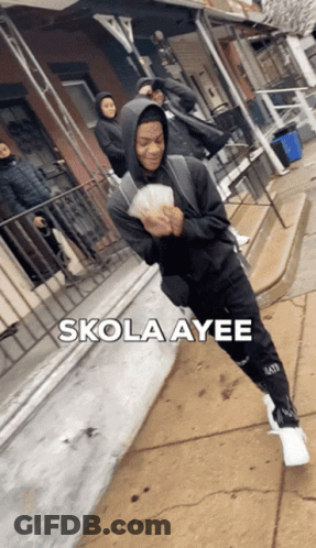 A Man In A Hoodie Is Holding A Bunch Of Money And The Words Skola Ayee Are Above Him GIF