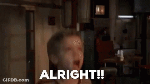 A Man In A Hoodie Is Sitting In Front Of A Window And Says `` Alright '' . GIF