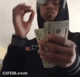 A Man In A Hoodie Is Smoking A Cigarette While Holding A Bunch Of Money . GIF