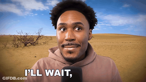 A Man In A Hoodie Says " I 'Ll Wait " In Front Of A Desert GIF