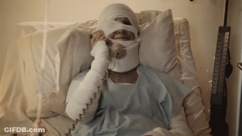 A Man In A Hospital Bed With A Bandaged Head Talking On A Phone GIF