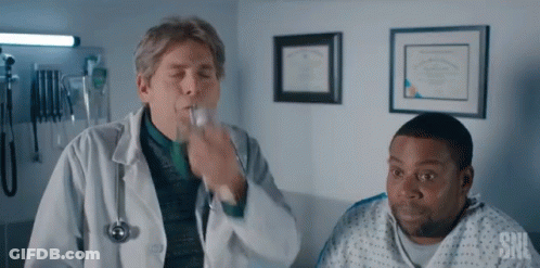 A Man In A Hospital Gown Is Talking To A Doctor Who Is Blowing A Whistle . GIF