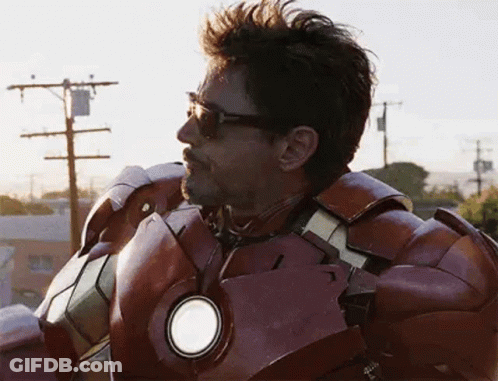 A Man In A Iron Man Suit Is Standing On Top Of A Building . GIF