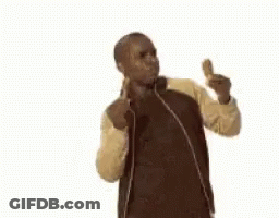 A Man In A Jacket Is Eating A Fried Chicken Wing And Giving A Thumbs Up . GIF