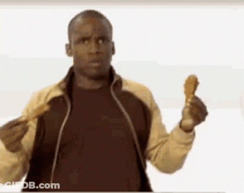 A Man In A Jacket Is Holding A Fried Chicken Wing In His Hand . GIF