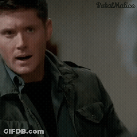 A Man In A Jacket Is Holding A Necklace In His Hand . GIF