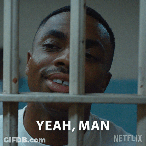 A Man In A Jail Cell Behind Bars With The Words Yeah Man Written Below Him GIF
