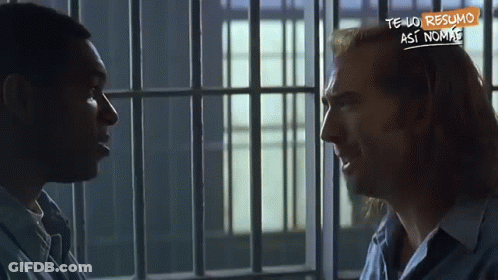 A Man In A Jail Cell Talking To Another Man With A Sign That Says Tengo Resumo GIF