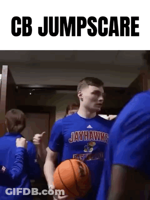A Man In A Jayhawks Shirt Is Holding A Basketball And Giving A Thumbs Up . GIF
