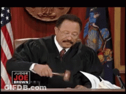 A Man In A Judge 'S Robe Is Holding A Gavel In Front Of A Sign That Says Judge Joe Brown GIF