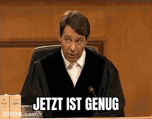 A Man In A Judge 'S Robe Is Sitting In Front Of A Microphone And Says Jetzt Ist Genug GIF