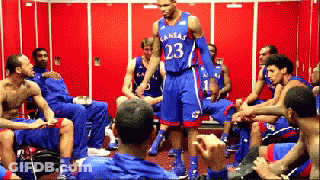 A Man In A Kansas Jersey Stands In A Locker Room With His Teammates GIF