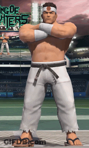 A Man In A Karate Outfit Stands With His Arms Crossed In Front Of A Sign That Says King Of Fighters GIF