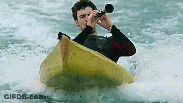 A Man In A Kayak Playing A Trumpet In The Water GIF