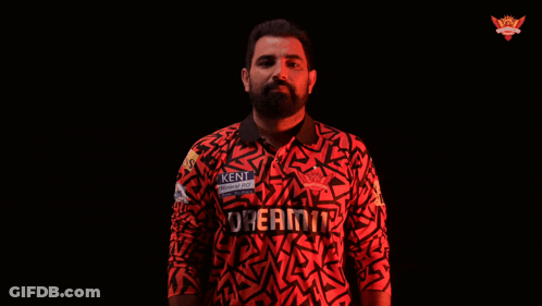 A Man In A Kent Shirt Is Holding A Ball GIF