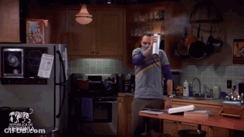 A Man In A Kitchen Holding A Box Of Mini Bites GIF