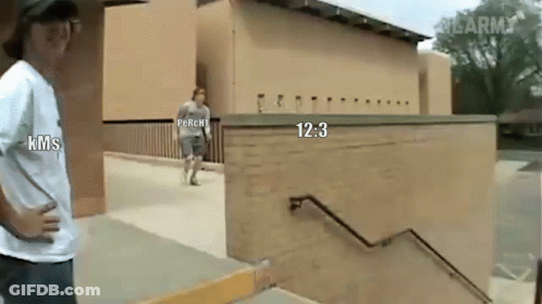 A Man In A Kms Shirt Stands Next To A Man In A Perchi Shirt GIF