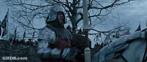 A Man In A Knight 'S Armor Is Riding A Horse In Front Of A Crowd GIF