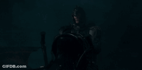 A Man In A Knight 'S Armor Is Riding A Horse In The Dark . GIF