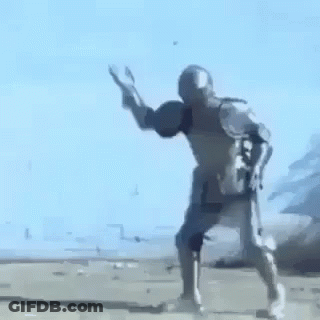 A Man In A Knight 'S Armor Is Standing On A Dirt Road . GIF