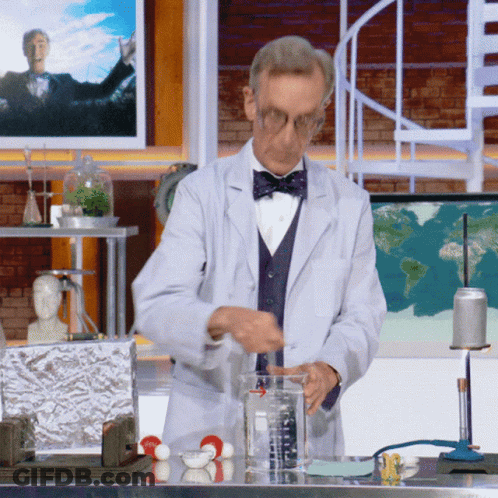 A Man In A Lab Coat And Bow Tie Is Measuring Liquid GIF