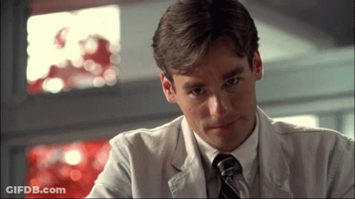 A Man In A Lab Coat And Tie Is Looking Down GIF