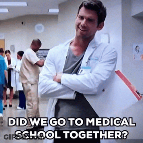 A Man In A Lab Coat Is Standing In A Hospital Hallway With His Arms Crossed And The Caption Did We Go To Medical School GIF