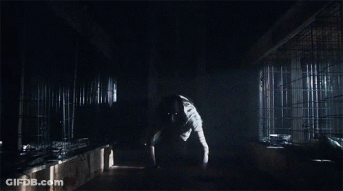 A Man In A Lab Coat Is Standing In The Dark GIF