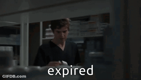 A Man In A Lab Coat Is Talking To Another Man In A Pharmacy And The Word Expired Is Visible GIF